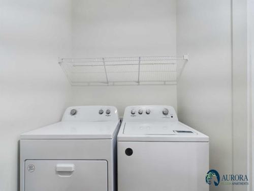 Apartments for rent in Ocala A white laundry room features a washing machine and dryer side by side with a wire shelf above them. Aurora St. Leon Apartments logo is in the bottom right corner. Aurora St. Leon Apartments in Ocala 2150 NW 21st Avenue | Ocala, FL 34475 (352) 233-4133