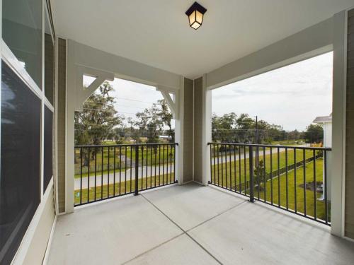 Apartments for rent in Ocala Covered balcony with metal railing, beige walls, and a ceiling light overlooking a grassy area with trees and distant power lines. Aurora St. Leon Apartments in Ocala 2150 NW 21st Avenue | Ocala, FL 34475 (352) 233-4133