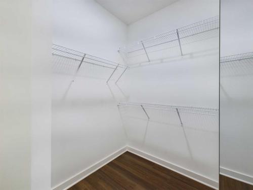 Apartments for rent in Ocala Empty closet with white walls and wire shelving on two sides. The floor is made of dark wood. Aurora St. Leon Apartments in Ocala 2150 NW 21st Avenue | Ocala, FL 34475 (352) 233-4133