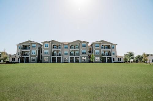 Apartments for rent in Ocala A three-story apartment building with balconies, set in a grassy open area under a clear sky. Aurora St. Leon Apartments in Ocala 2150 NW 21st Avenue | Ocala, FL 34475 (352) 233-4133