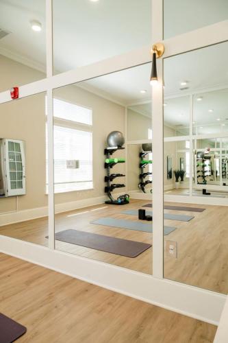Apartments for rent in Ocala A well-lit fitness studio with wall mirrors, exercise mats on the floor, and a rack holding weights and exercise balls. Aurora St. Leon Apartments in Ocala 2150 NW 21st Avenue | Ocala, FL 34475 (352) 233-4133