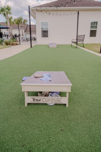 Apartments for rent in Ocala Outdoor cornhole game setup on artificial turf, featuring a Trex Cornhole board with bean bags scattered on and around it. Aurora St. Leon Apartments in Ocala 2150 NW 21st Avenue | Ocala, FL 34475 (352) 233-4133